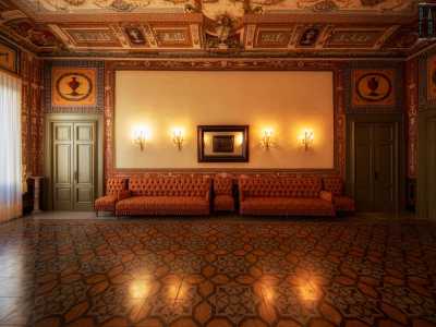 ...sono decorate con una serie di candelabri dorati e una specchiera in legno. Pi� in basso, le tonalit� accese delle trame dei divanetti...